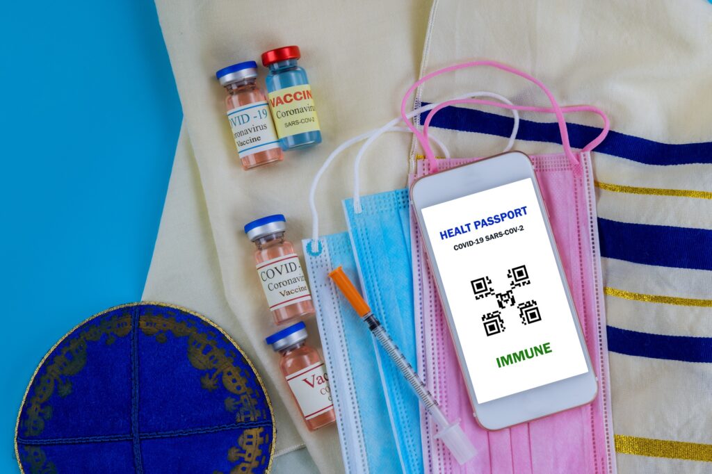 Israel vaccination certificate with a Covid-19 vaccine bottle, syringe immunization document, a fac